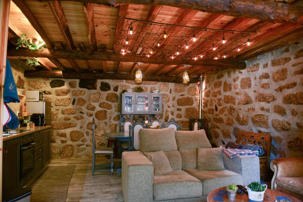 ein Wohnzimmer mit einem Sofa und einem Tisch in der Unterkunft Casa dos Alcaides in Sabugueiro