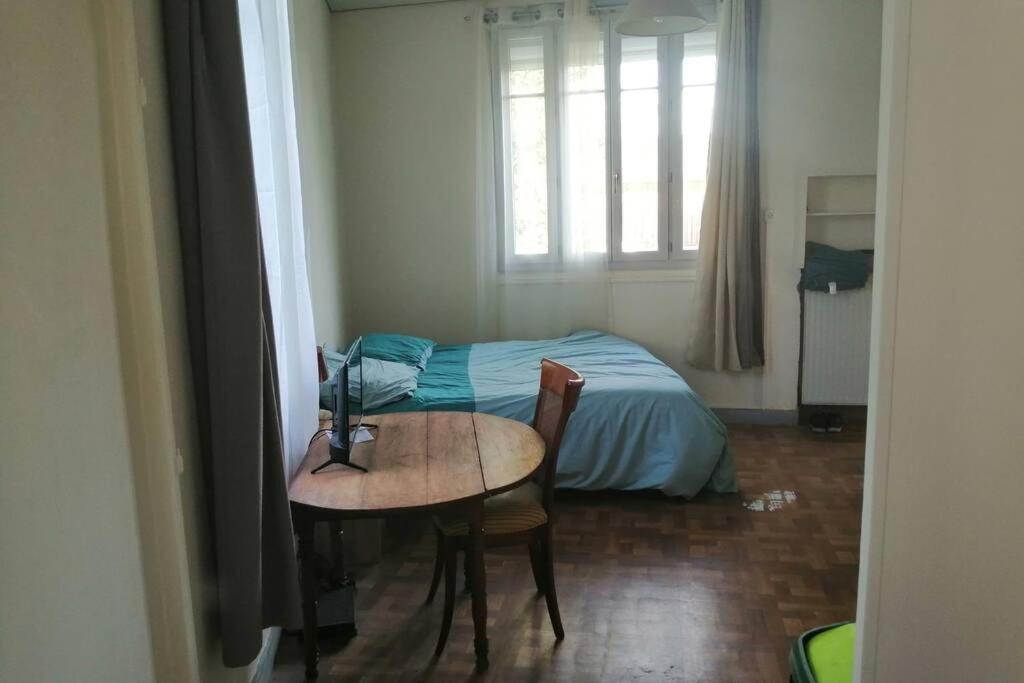 ein kleines Zimmer mit einem Tisch und einem Bett in der Unterkunft Au calme, devant le port, studio indépendant in Lere