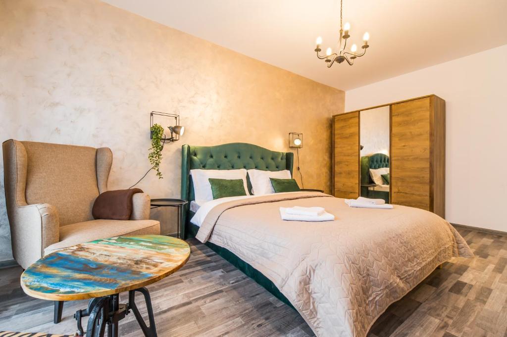 1 dormitorio con 1 cama grande y 1 silla en Apartament Smarald en Brasov