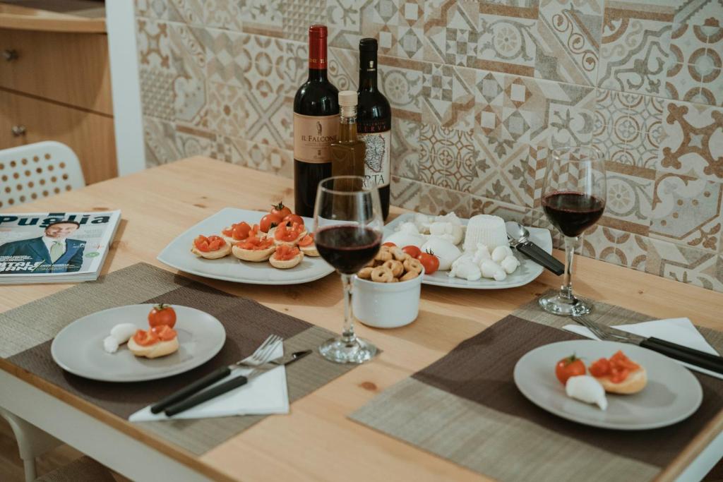 un tavolo con tre piatti di bicchieri da cibo e vino di La casetta di Nonna Giovanna a Noci