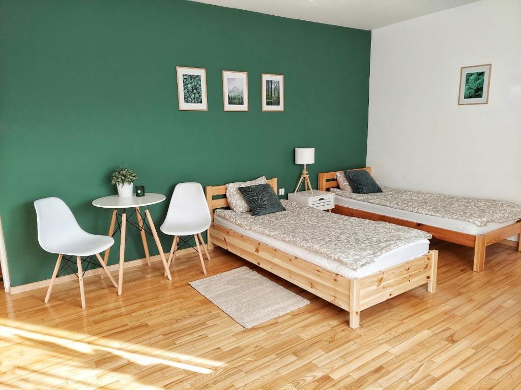 duas camas num quarto com mesa e cadeiras em Dommieszkalny em Augustów