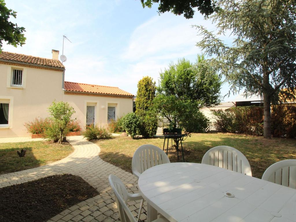 una mesa blanca y sillas en un patio en Gîte Chemillé-en-Anjou-Chemillé-Melay, 4 pièces, 6 personnes - FR-1-622-8 en Saint-Georges-du-Puy-de-la-Garde