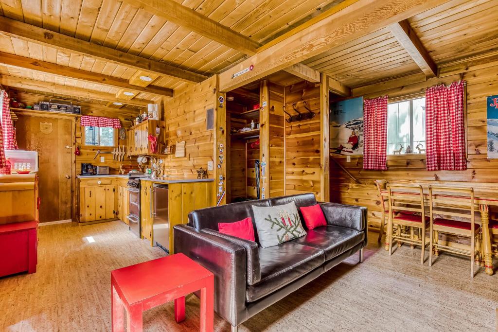 a living room with a leather couch and a table at Sno-bird #8 in Government Camp