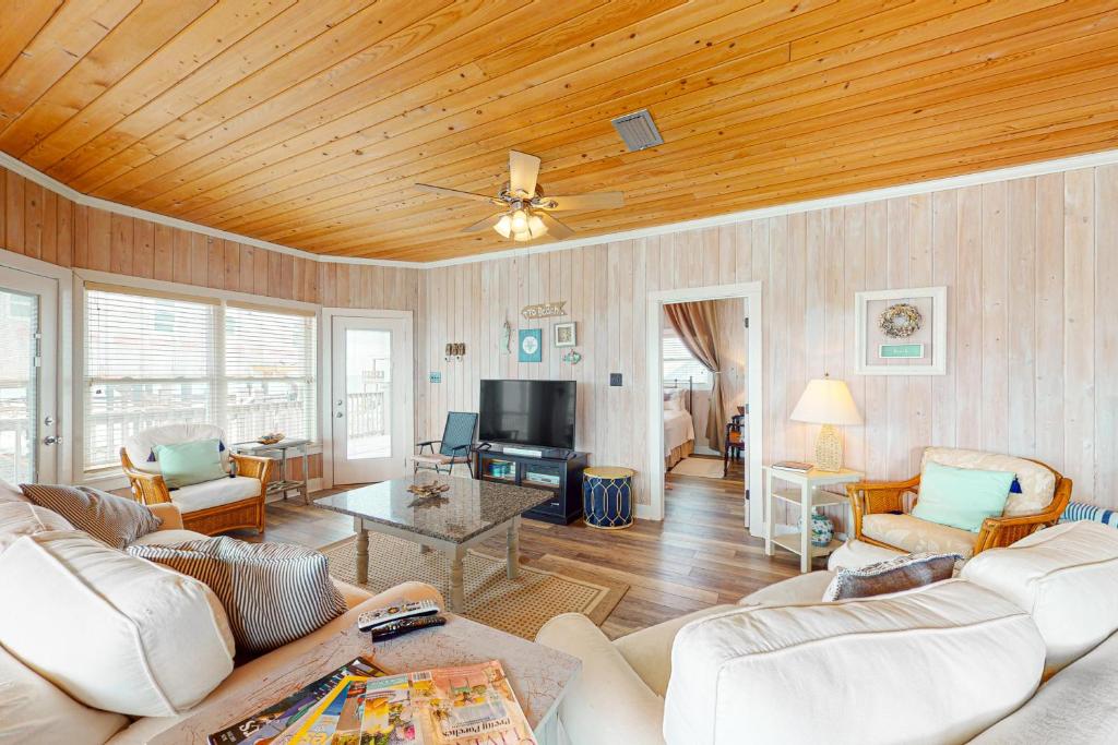 ein Wohnzimmer mit weißen Möbeln und einer Holzdecke in der Unterkunft Beach Haven in Dauphin Island