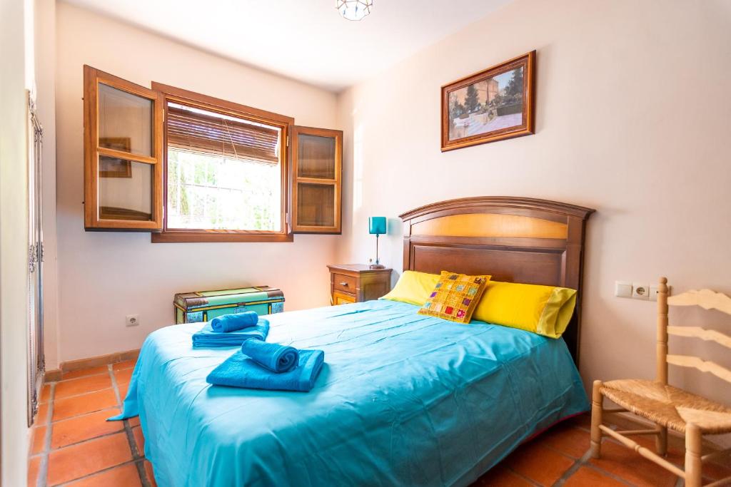 Un dormitorio con una cama con toallas azules. en tuGuest Aljibe del Rey Apartment en Granada