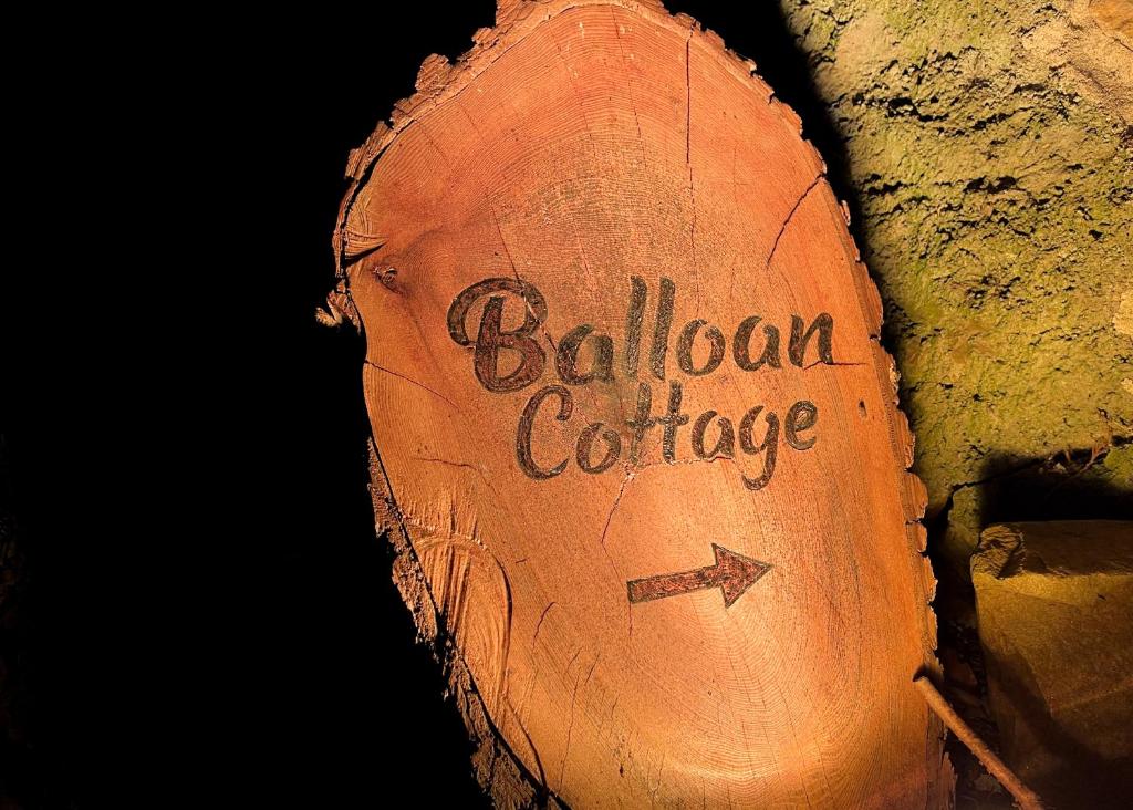 un tronco con las palabras "Casa de campo de mortadela" escritas en él en Balloan Cottage en Inverness