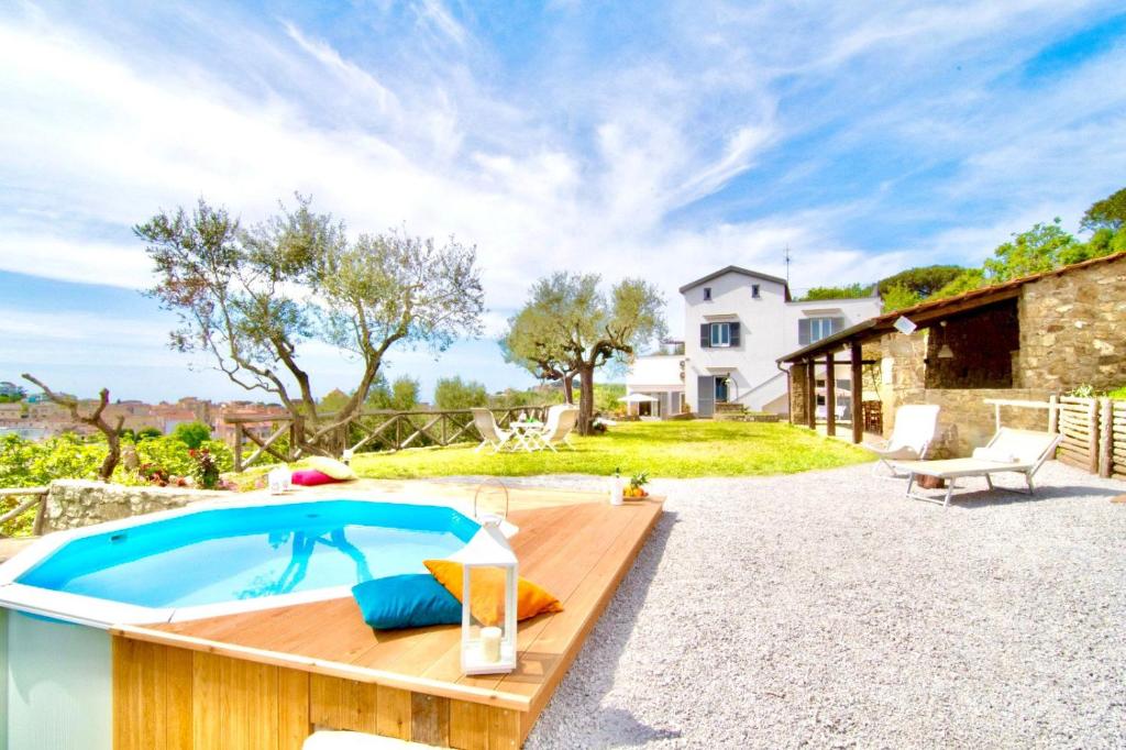 un patio trasero con piscina y una casa en Villa dei Golfi, en SantʼAgata sui Due Golfi
