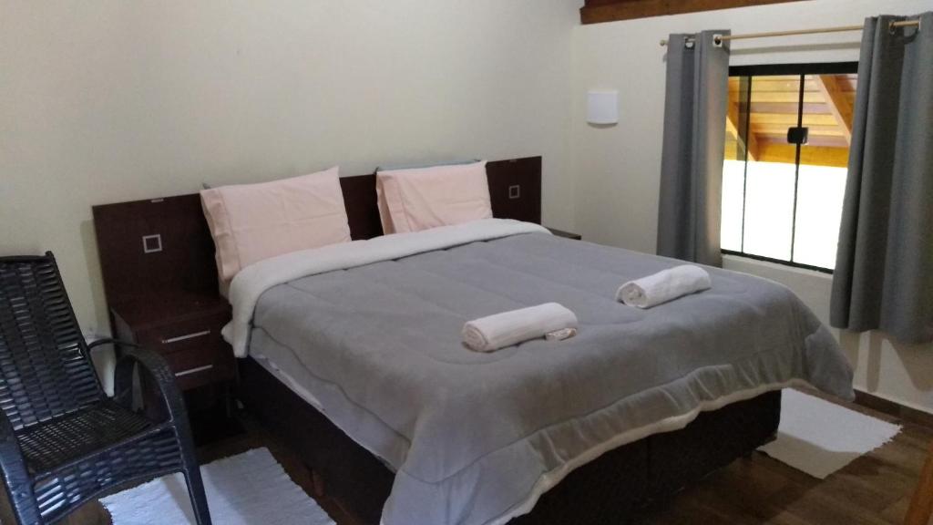 ein Schlafzimmer mit einem Bett mit zwei Handtüchern darauf in der Unterkunft Chalé Portal Lazer in Gonçalves