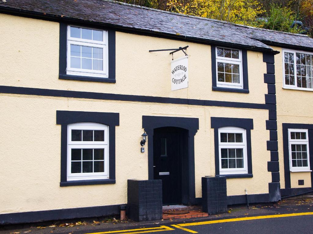 a white and black building with a black door at Hafan in Llangollen
