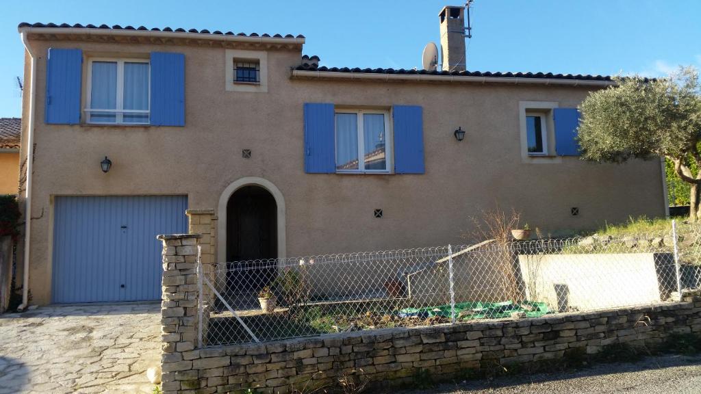 una casa con ventanas con persianas azules y una valla en Chambres d'hôtes Elisa & Etienne, en Manosque