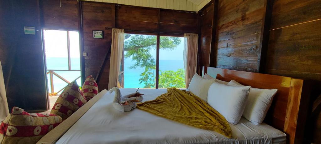 a bedroom with a large bed with a window at Wilton House Oceanview Cabin in Mearnsville