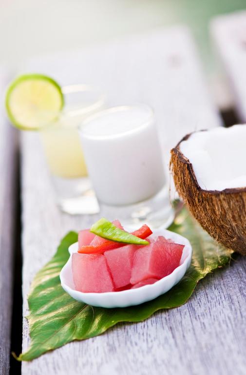 a plate of watermelon on a table with a drink at Maitai Rangiroa in Avatoru