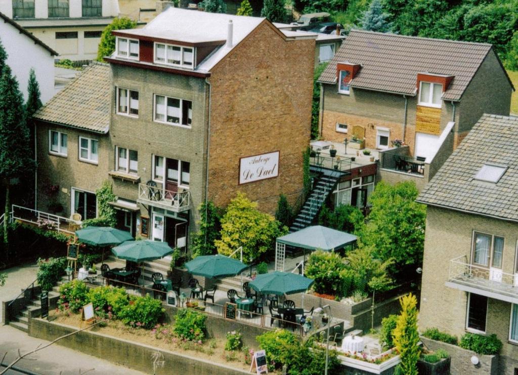 une vue aérienne sur un bâtiment avec des tables et des parasols dans l'établissement Pension Auberge de Dael, à Fauquemont