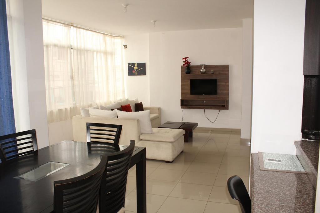- un salon avec une table et un canapé dans l'établissement Departamentos de 2 y 3 Habitaciones en el Centro de MANTA, à Manta
