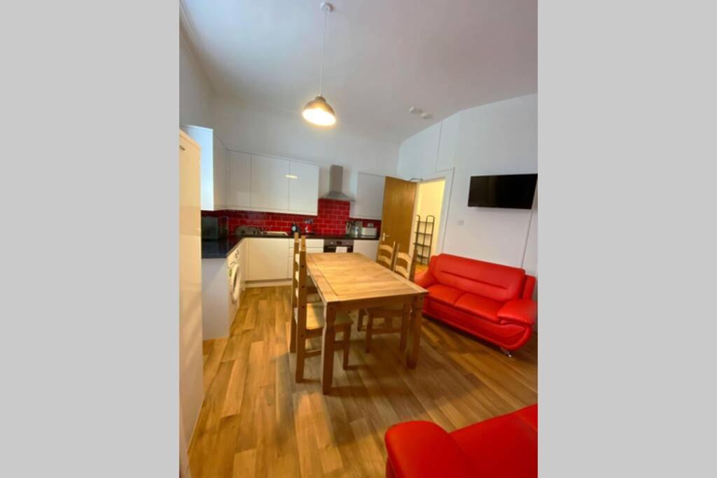 sala de estar con mesa y sofá rojo en 300 yards from Old course and St Andrews centre en St Andrews