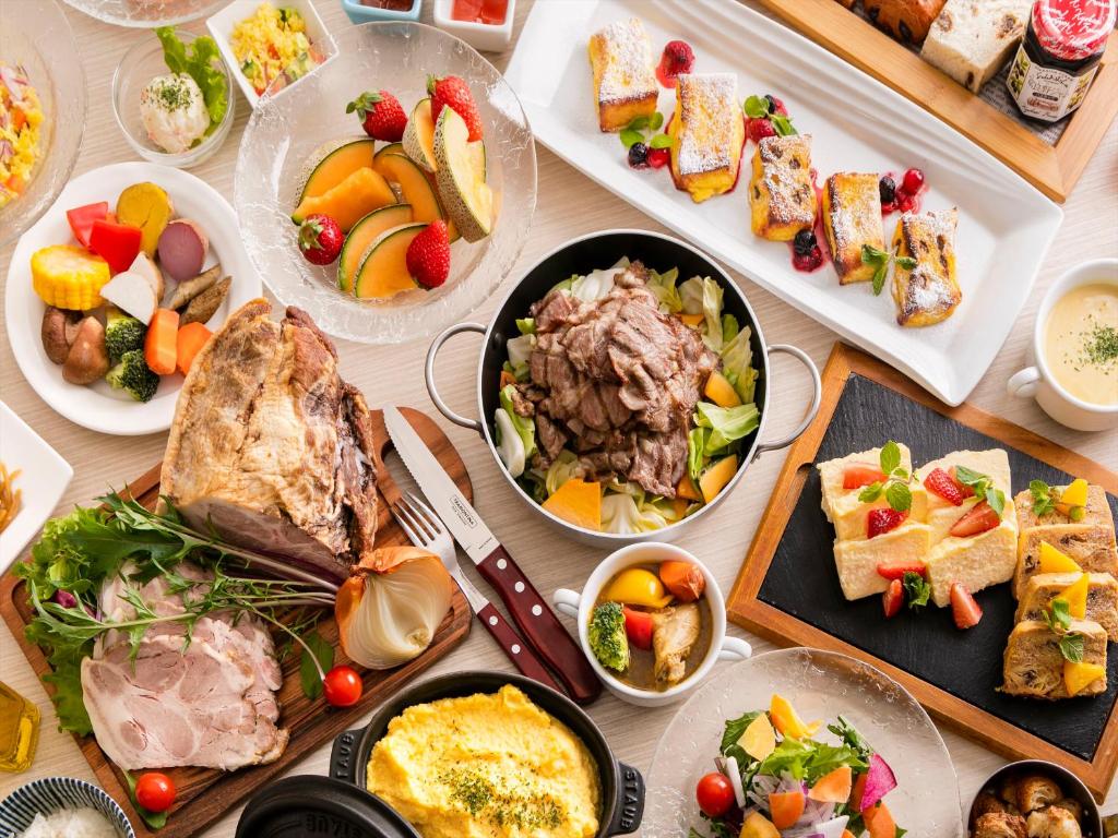 une table avec de nombreuses assiettes de nourriture dans l'établissement Tenza Hotel & SKYSPA at Sapporo Central, à Sapporo