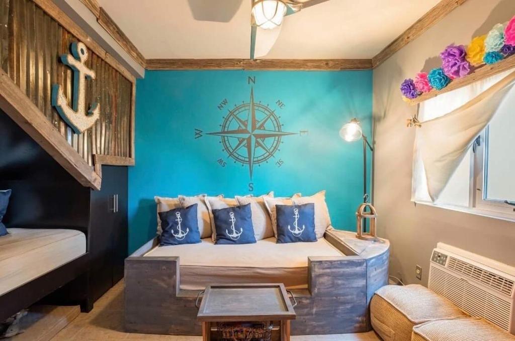 a room with a bed with a nautical sign on the wall at Sol-O-Cien Condo in Rosarito