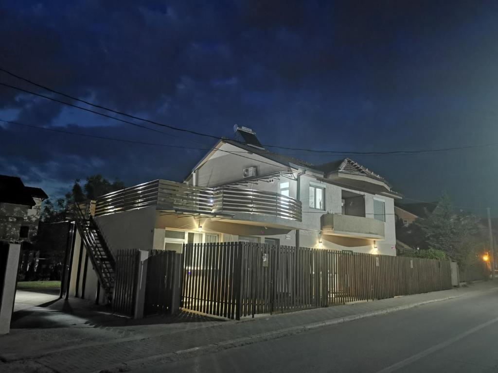 una casa bianca con una recinzione su una strada di notte di Crown Apartments a Skopje