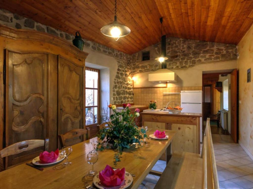 a kitchen with a wooden table with flowers on it at Gîte Essertines-en-Châtelneuf, 3 pièces, 6 personnes - FR-1-496-16 in Essertines-en-Châtelneuf