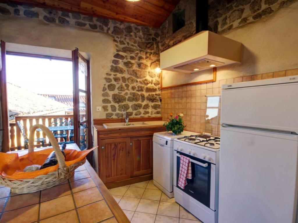 a kitchen with a stove and a white refrigerator at Gîte Essertines-en-Châtelneuf, 3 pièces, 6 personnes - FR-1-496-16 in Essertines-en-Châtelneuf