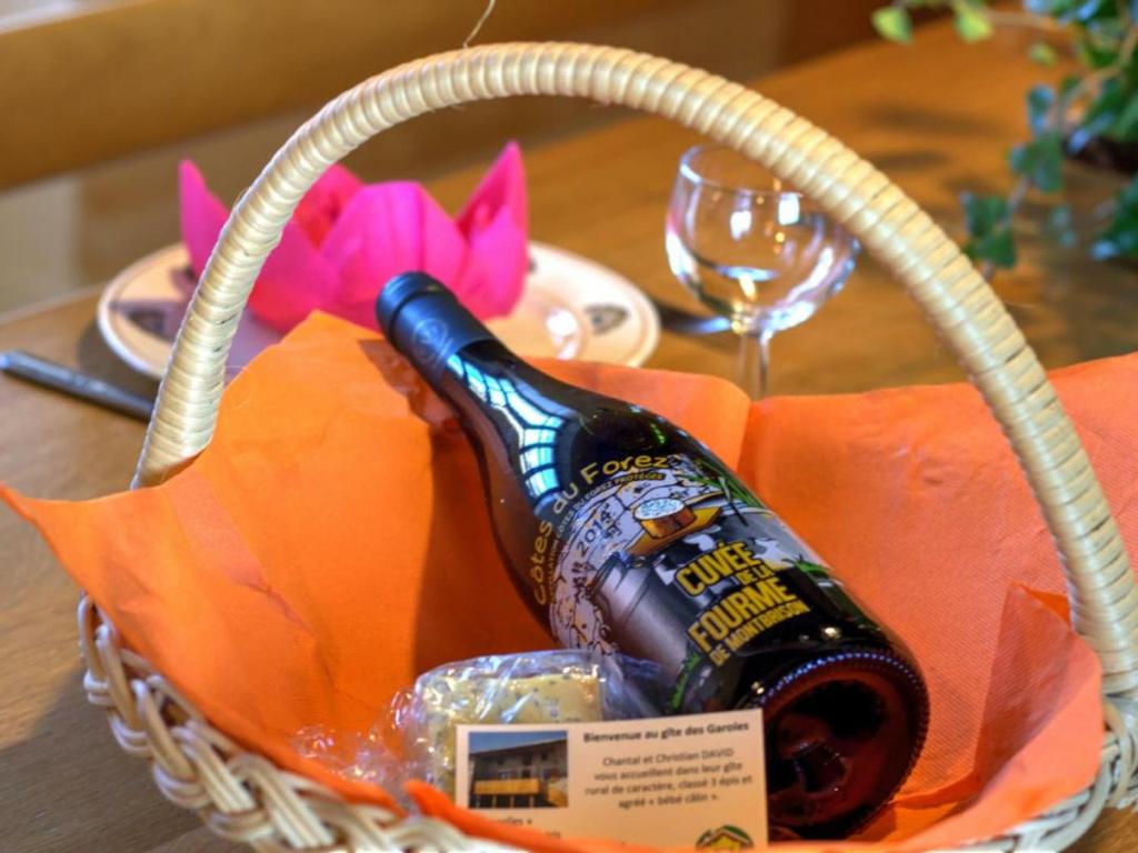 a basket with a bottle of wine on a table at Gîte Essertines-en-Châtelneuf, 3 pièces, 6 personnes - FR-1-496-16 in Essertines-en-Châtelneuf