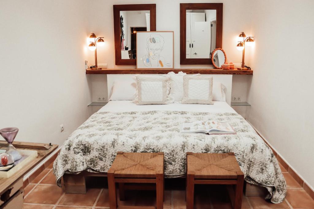 1 dormitorio con 1 cama con 2 mesas y 2 espejos en Catalina Beach House by Cassai, en Colonia de Sant Jordi