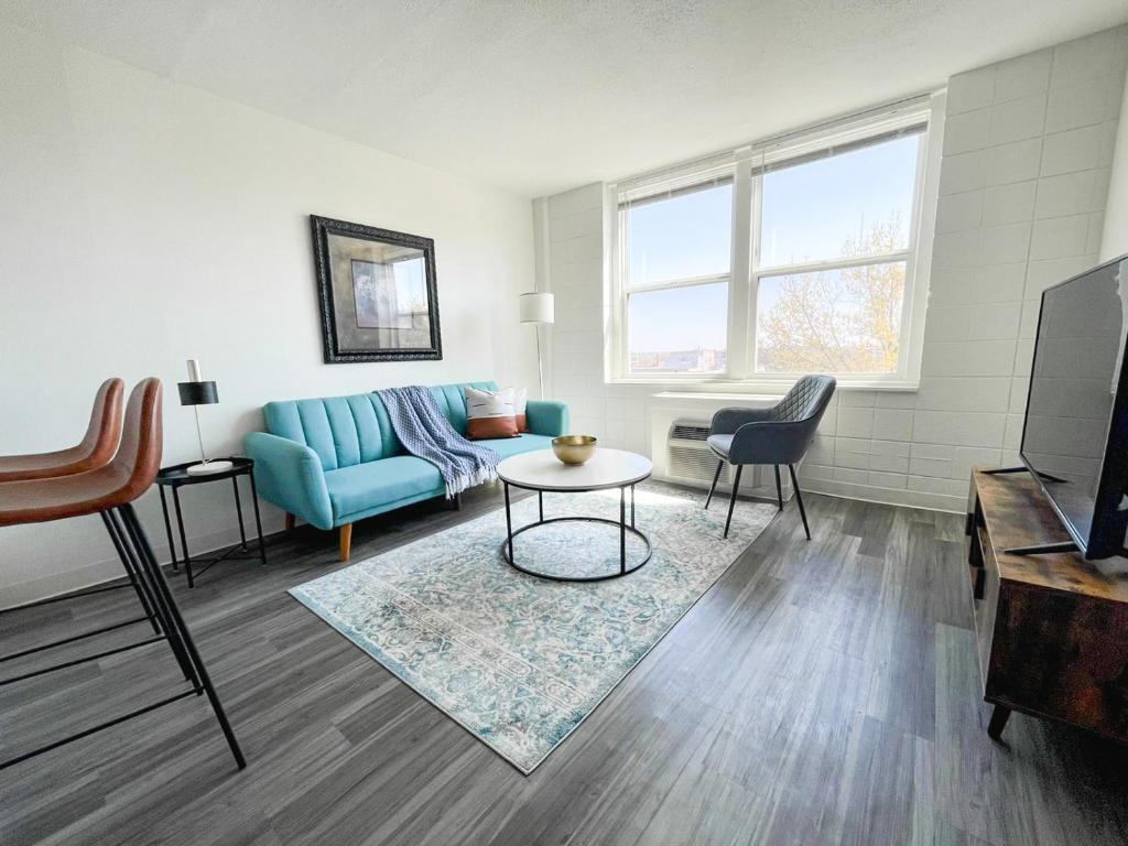 ein Wohnzimmer mit einem blauen Sofa und einem Tisch in der Unterkunft Sleepover Downtown Cincinnati 1BD 1BA Apartments in Cincinnati