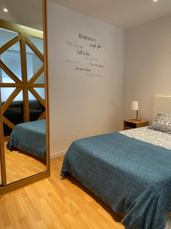リスボンにあるApartment Beco das Farinhasの鏡付きのベッドルーム(ベッド1台、ベッド1台付)