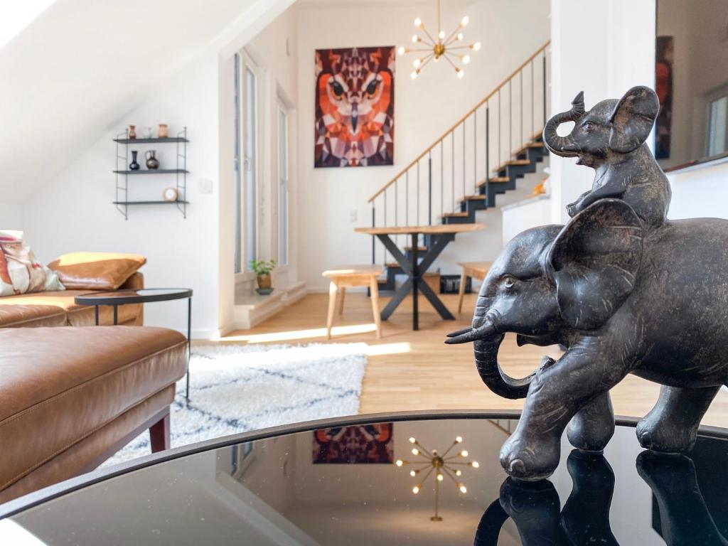 a living room with a statue of an elephant on a table at Modern & Stylisch: Maisonette Wohnung in Freising in Freising