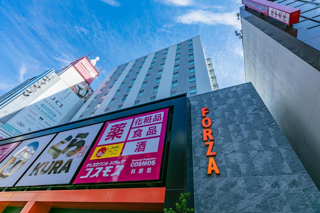 un grand bâtiment avec un panneau devant lui dans l'établissement Hotel Forza Osaka Namba, à Osaka