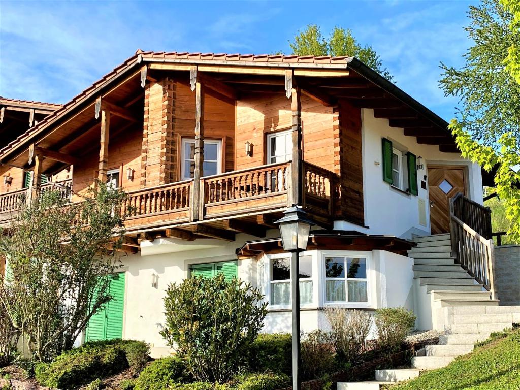Casa de madera con balcón y escaleras en Suite Heidi am Golfplatz Uttlau-Haarbach, en Haarbach