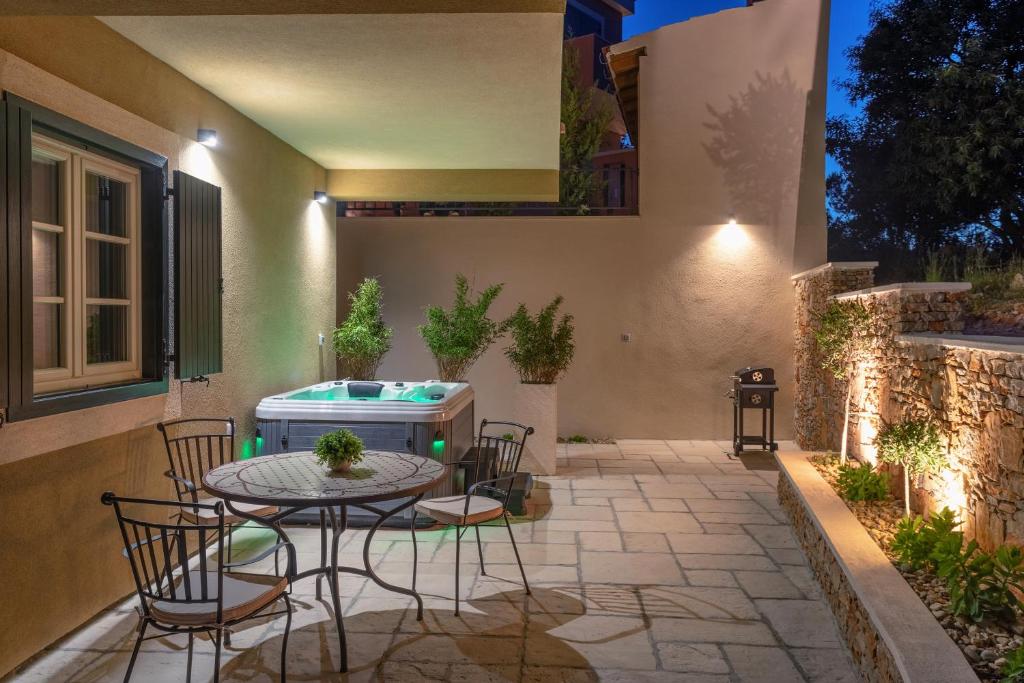 une terrasse avec une table et des chaises ainsi qu'un bain à remous dans l'établissement TEONA Luxury Studio Apartment with jacuzzi and garden view, à Sali