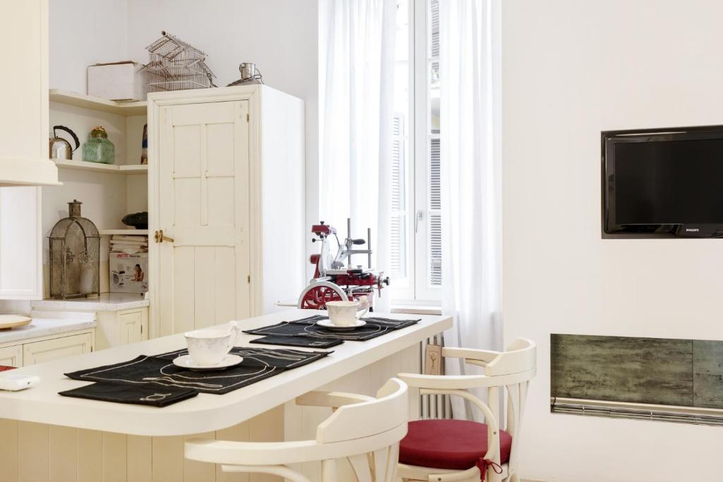 une cuisine avec un îlot blanc et des chaises blanches dans l'établissement Appartamento Suite Design Parma, à Parme