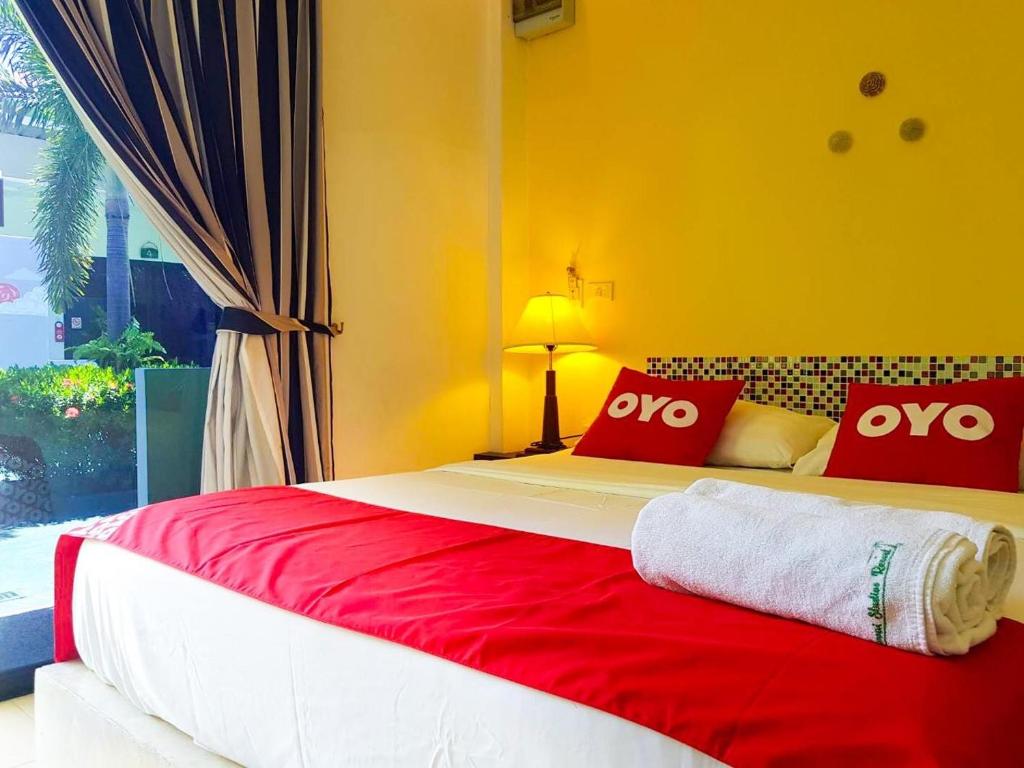 a bedroom with a large bed with red and white pillows at Rawai Whale Resort in Rawai Beach