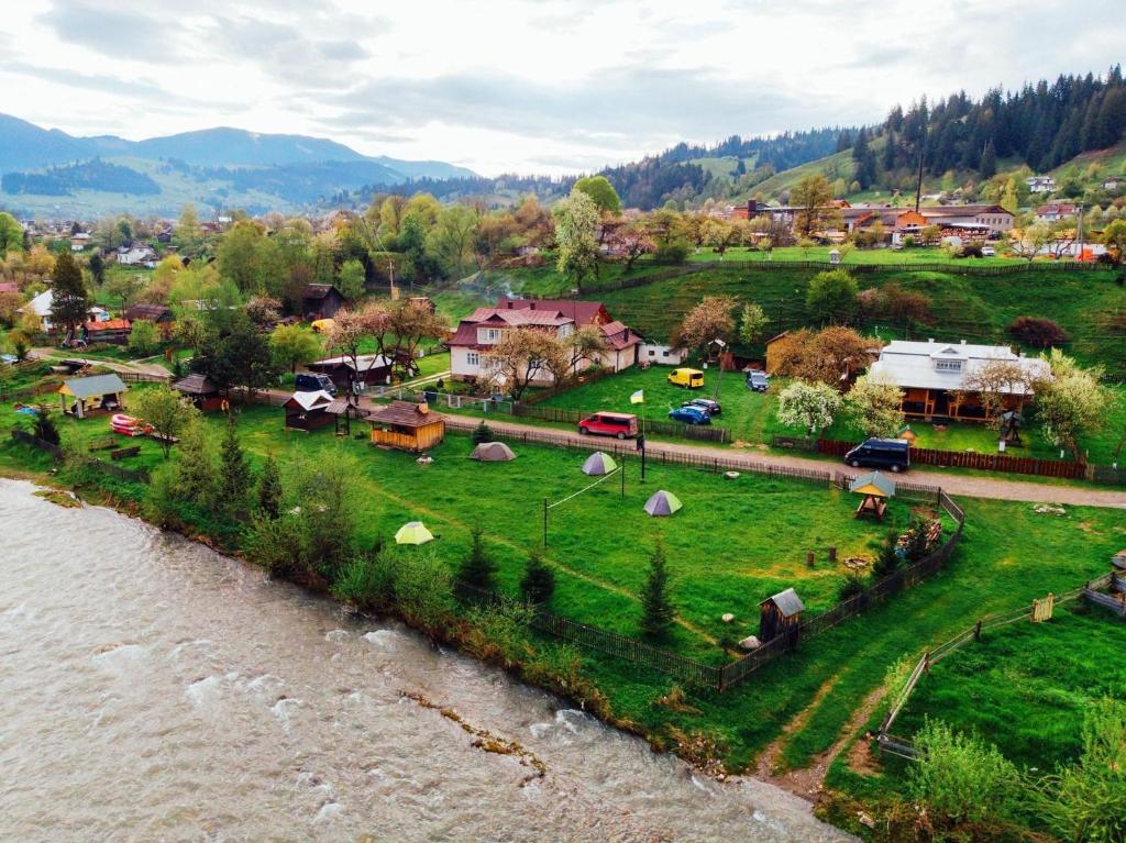 eine Gruppe von Zelten auf einem Feld neben einem Fluss in der Unterkunft Shum Cheremosha in Werchowyna