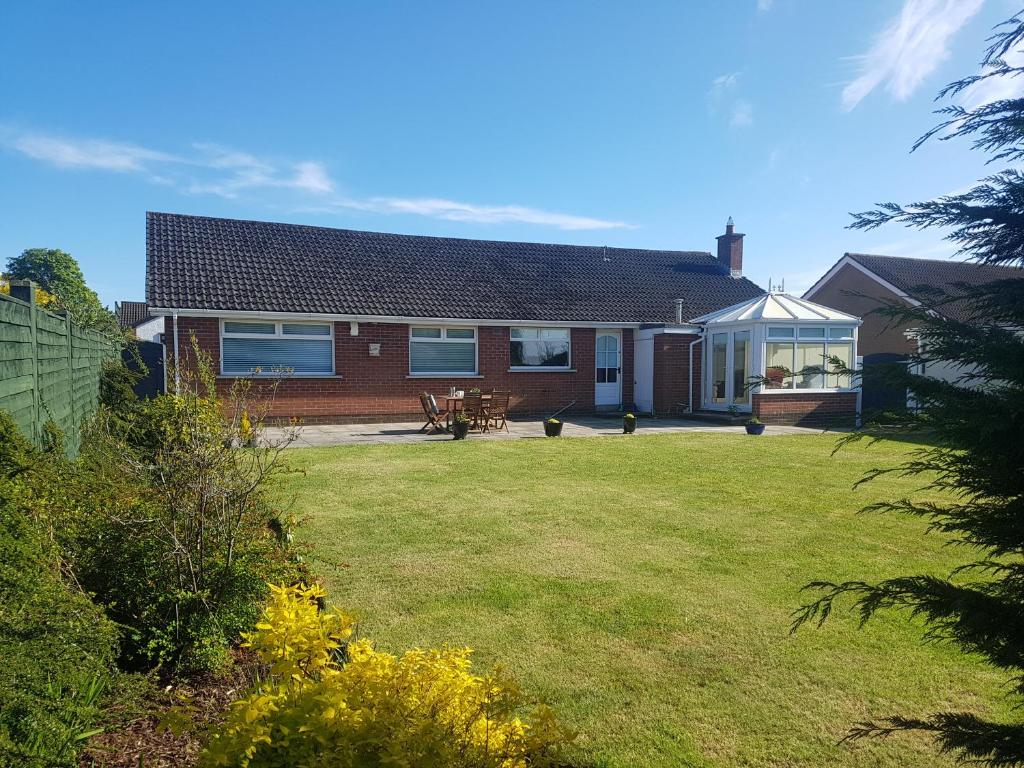 a house with a lawn in front of it at The Burrow, a Spacious Bungalow in Heart of NI in Templepatrick
