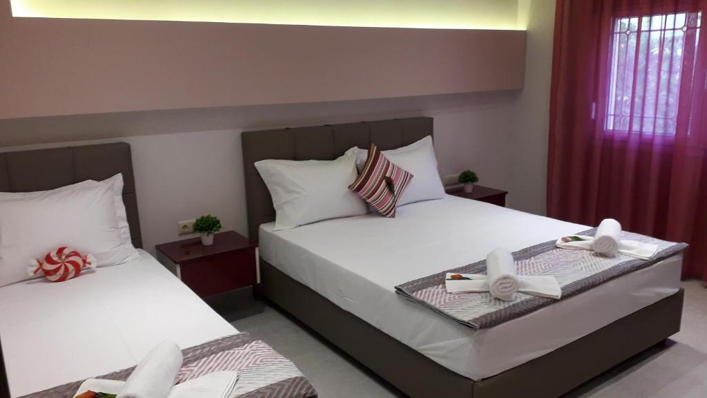 HOUSE DILENA TSIMTSIRI Luxury Apartment 1 في يميناريا: غرفة نوم بسريرين عليها اقواس
