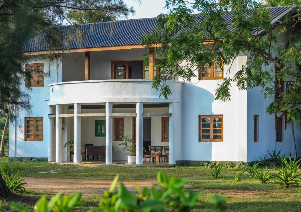 a house with a blue and white facade at KayJay Palms in Pasikuda