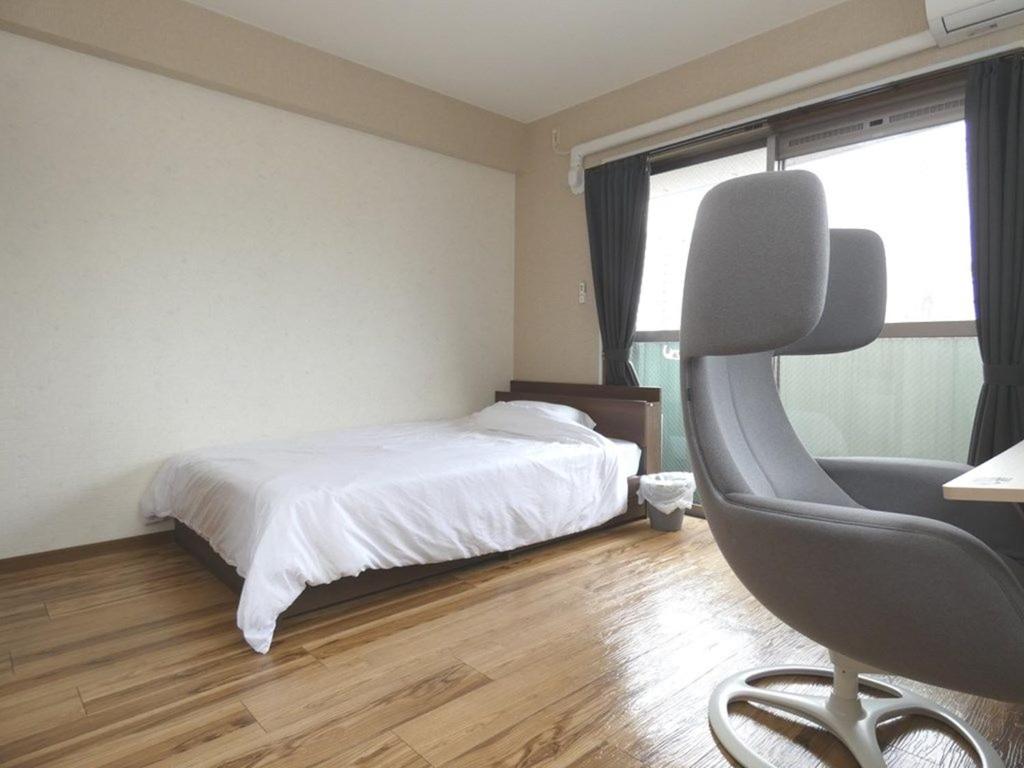 Schlafzimmer mit einem Bett, einem Schreibtisch und einem Stuhl in der Unterkunft AO Dazaifu - Vacation STAY 93787 in Chikushino
