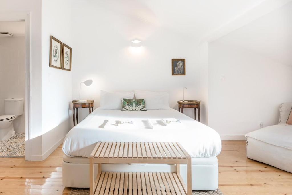 Habitación blanca con cama y sofá en Alarco - 55753AL, en Lisboa