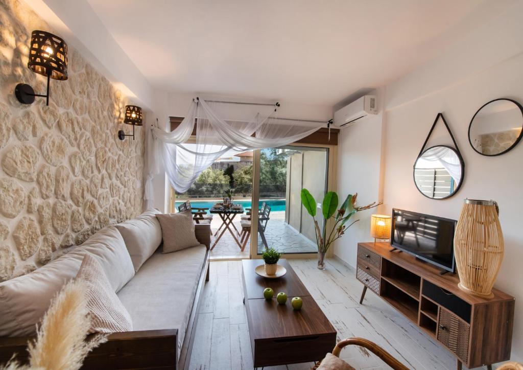 a living room with a couch and a tv at En Lefko Boutique Apartments in Nikiana