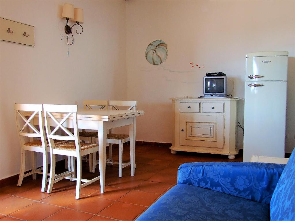 a living room with a table and a refrigerator at White Sand Residence in Murta Maria