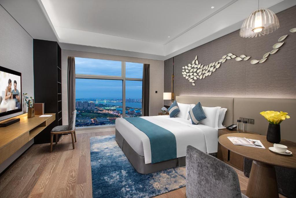 um quarto de hotel com uma cama e uma secretária em Ascott Xiangjiang FFC Changsha em Changsha