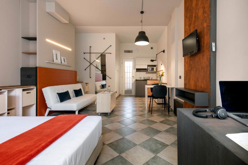 um quarto de hotel com uma cama e uma sala de estar em Residence 2Gi em Milão