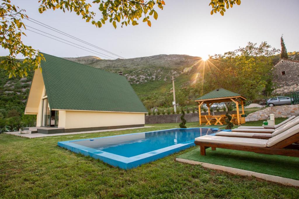 uma casa com uma piscina e um gazebo em Cozy House Ostrog em Nikšić