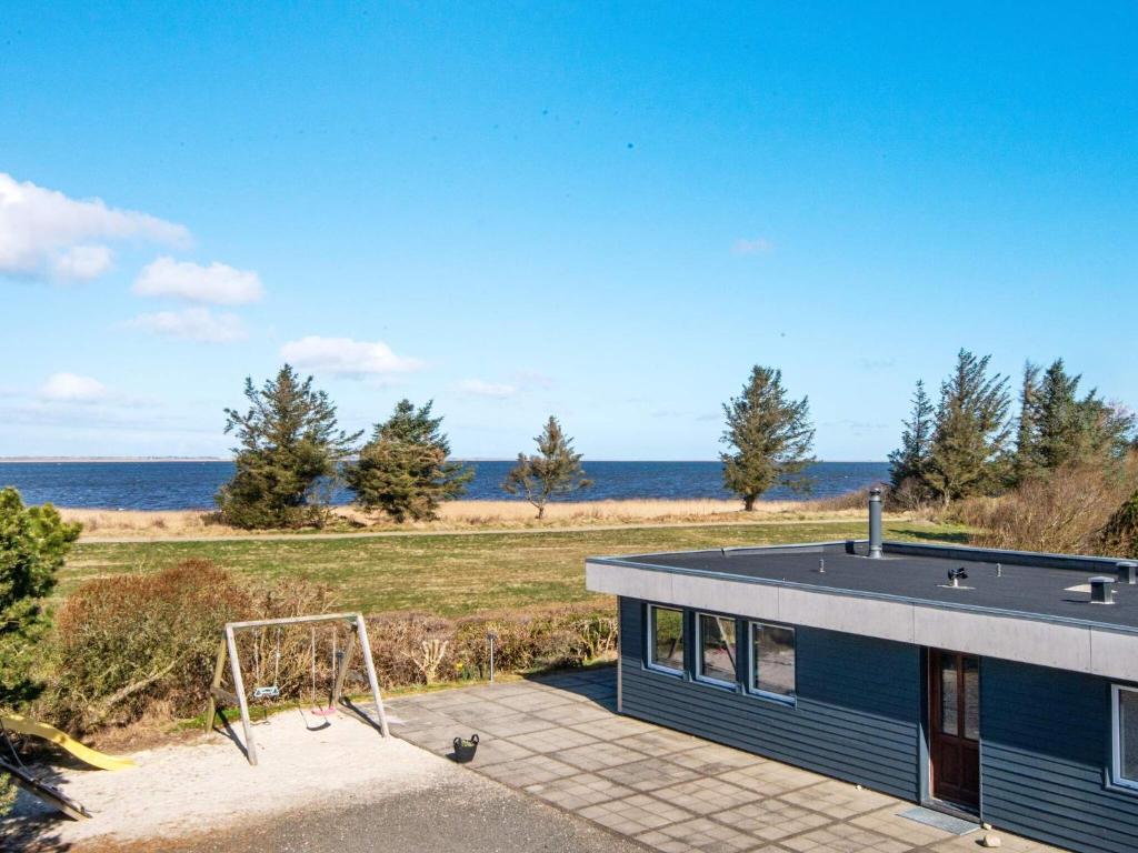 a blue house with a playground in front of the ocean at 8 person holiday home in Hemmet in Hemmet