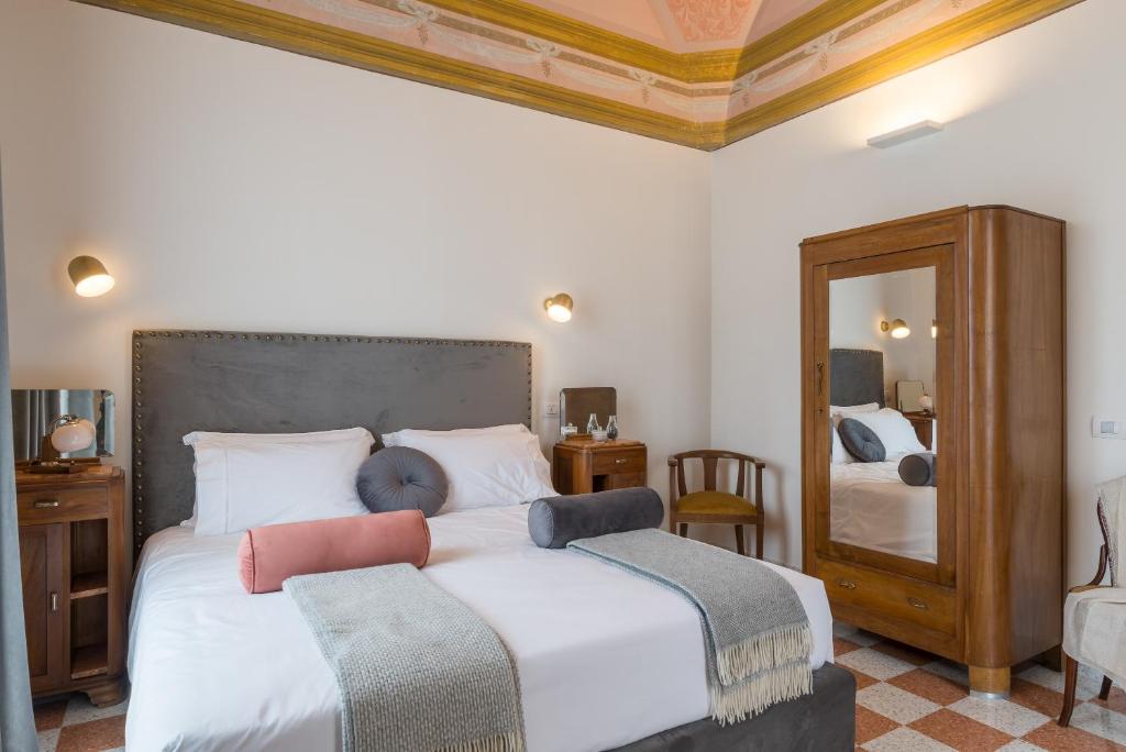 1 dormitorio con 2 camas y espejo en 1940 Luxury Accommodations by Wonderful Italy en Ostuni