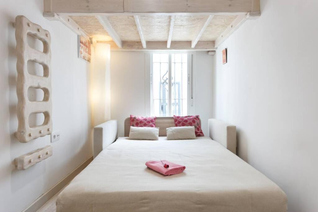 een kamer met een groot bed met een roze schoen bij PRECIOSO Y PEQUEÑO LOFT CENTRO DE CONIL in Conil de la Frontera