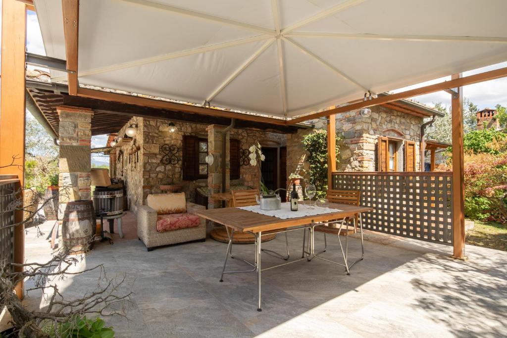 patio z drewnianym stołem i białym parasolem w obiekcie Villa Vepri by Mmega w mieście Cennina
