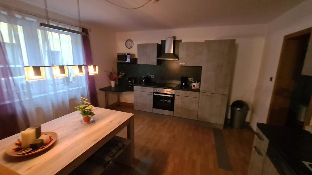 uma cozinha com uma mesa de madeira e uma bancada em Ferienwohnung Gottlebe em Ilmenau